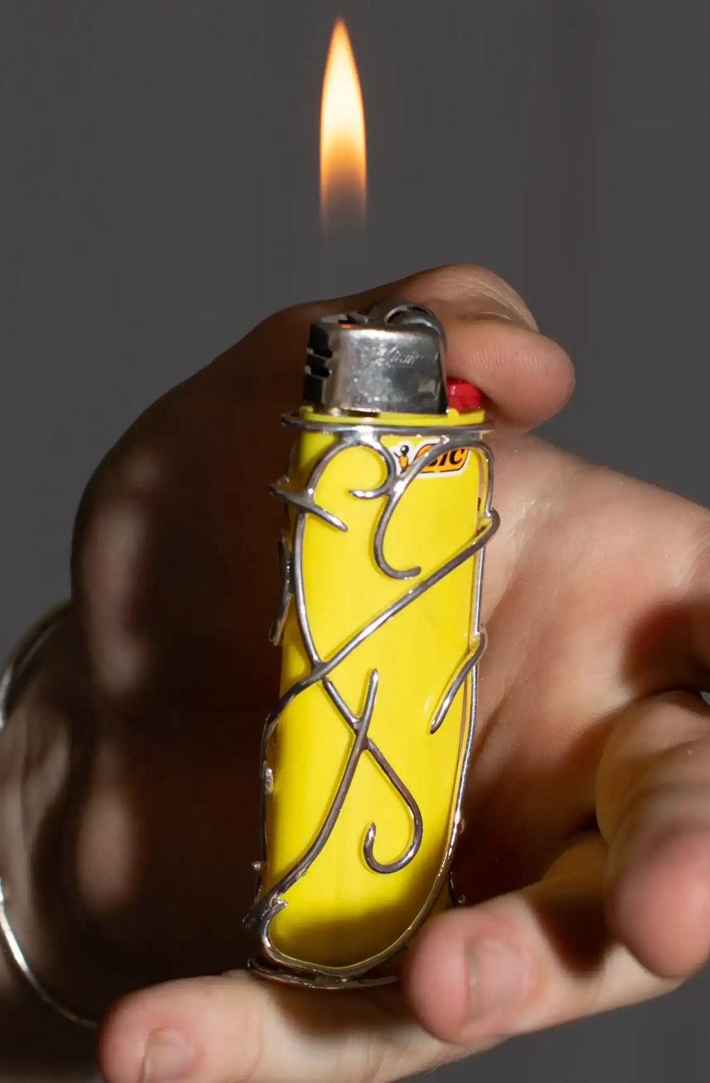 Sterling silver lighter case with branching wire pattern around a BIC lighter